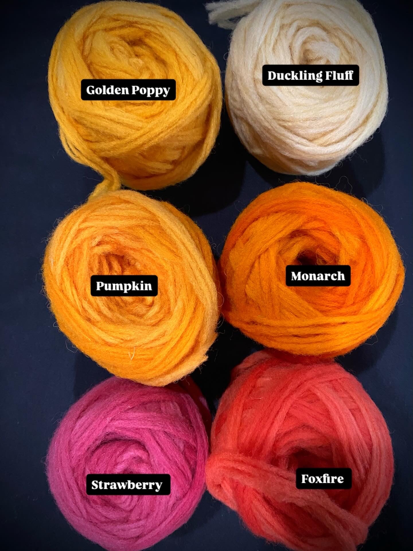 Six balls of yarn in different colors with labels on a dark background